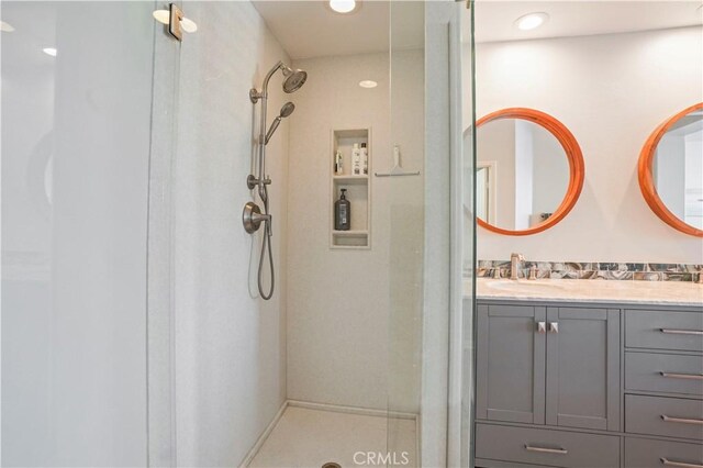 bathroom featuring walk in shower and vanity