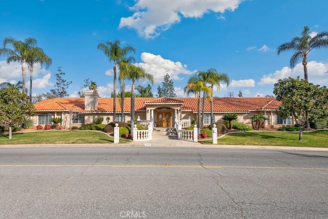 mediterranean / spanish-style house with a front yard