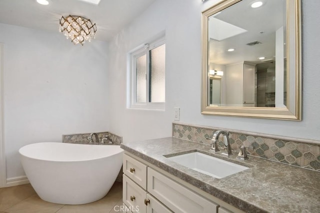 bathroom with vanity, backsplash, tile patterned floors, and a bathtub