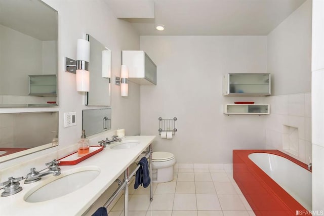 bathroom featuring a washtub, tile patterned floors, toilet, and vanity