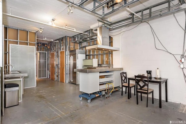 basement featuring sink and high end refrigerator