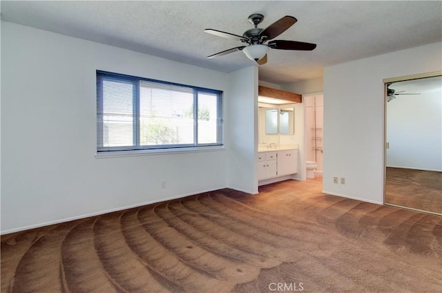 unfurnished bedroom featuring a closet, ceiling fan, ensuite bathroom, and light carpet