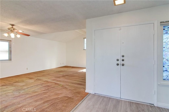 entryway with ceiling fan, light hardwood / wood-style floors, and lofted ceiling