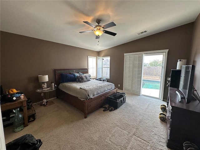 carpeted bedroom featuring access to exterior, vaulted ceiling, and ceiling fan