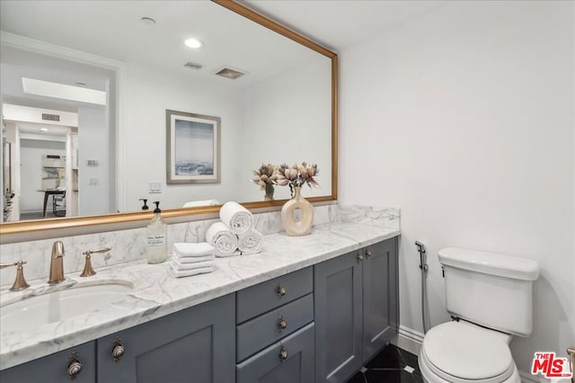 bathroom featuring vanity and toilet