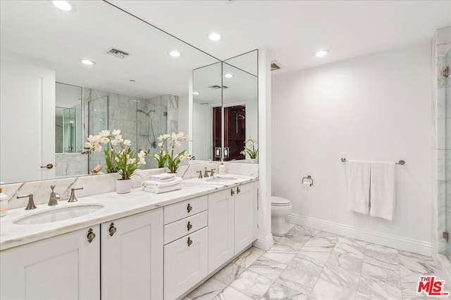 bathroom featuring vanity, a shower with door, and toilet