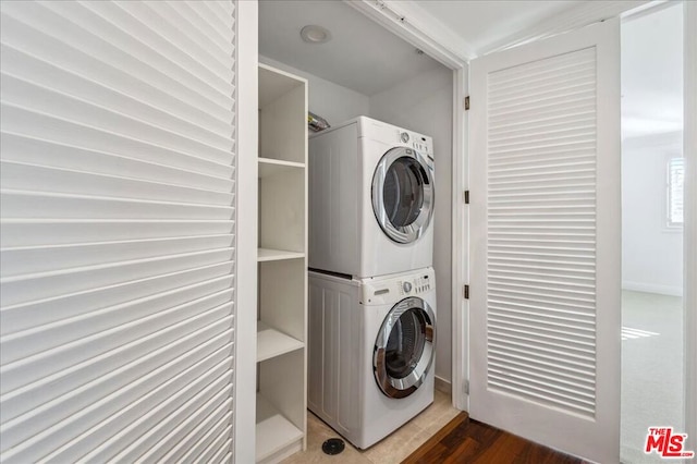 washroom with stacked washing maching and dryer and dark hardwood / wood-style floors