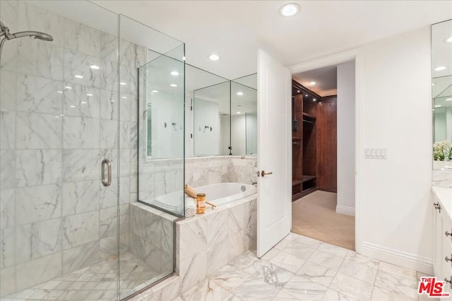 bathroom featuring vanity and independent shower and bath