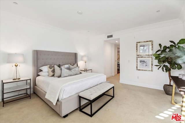 bedroom with light carpet and crown molding