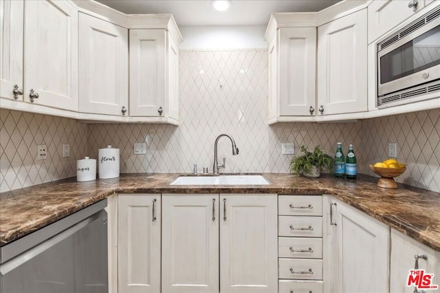 kitchen with stainless steel appliances, tasteful backsplash, sink, and white cabinets