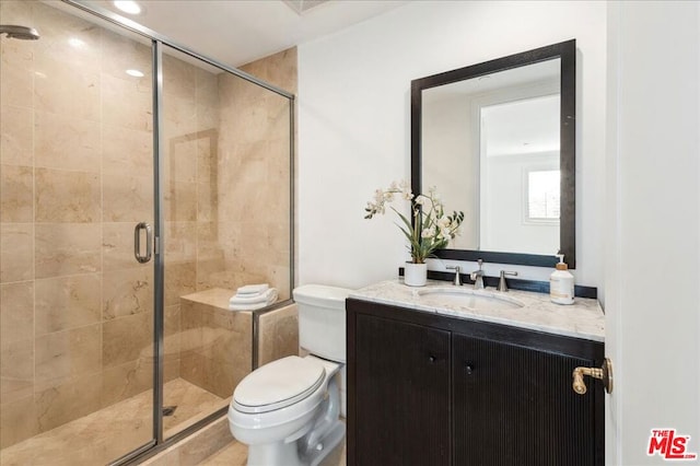 bathroom with vanity, toilet, and a shower with door