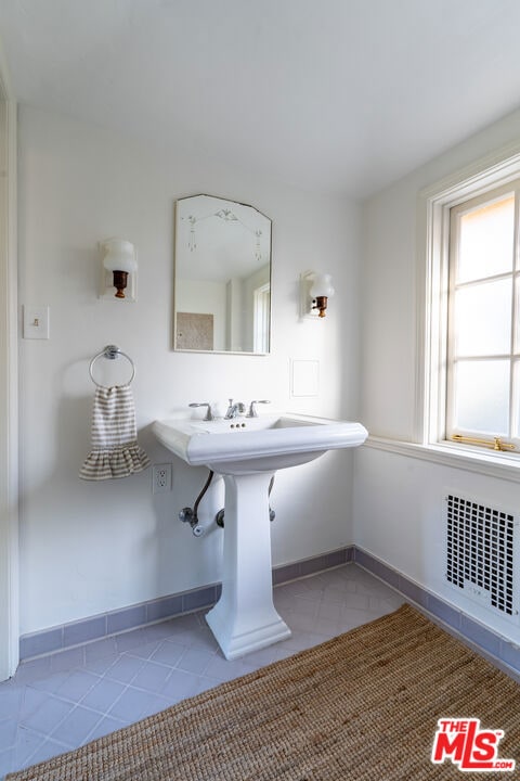 bathroom with sink, radiator heating unit, and tile patterned floors