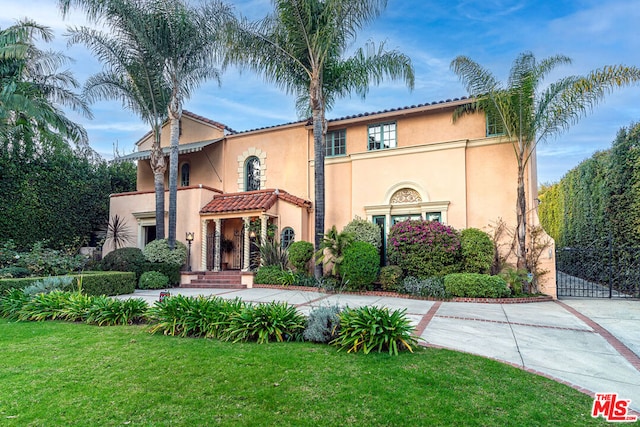 mediterranean / spanish-style house with a front yard