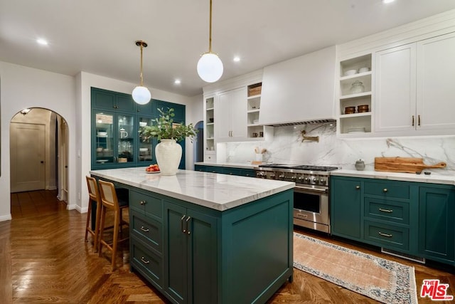 kitchen featuring premium range hood, white cabinetry, green cabinets, a center island, and stainless steel range