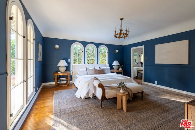 bedroom featuring an inviting chandelier and hardwood / wood-style floors