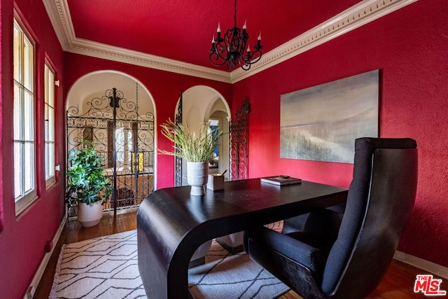 dining area featuring hardwood / wood-style floors, crown molding, and a chandelier