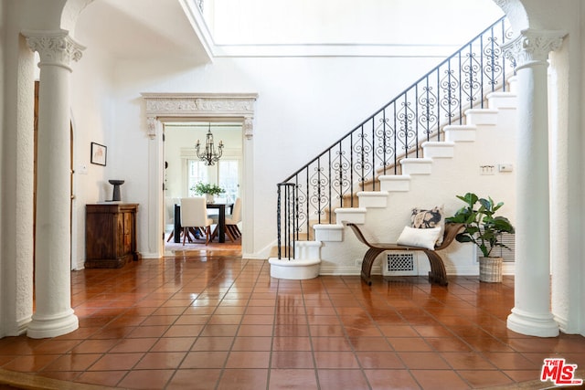 tiled foyer entrance featuring decorative columns and a high ceiling