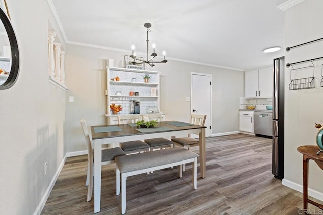 dining space with a chandelier, crown molding, and wood-type flooring