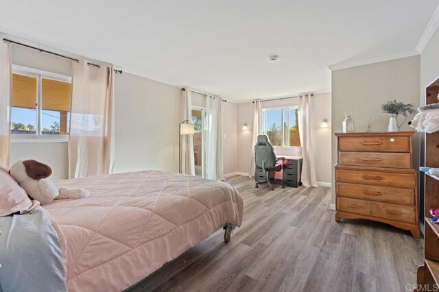 bedroom with light wood-type flooring and ornamental molding