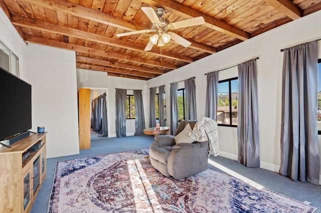 living room featuring carpet floors, beam ceiling, ceiling fan, and wood ceiling