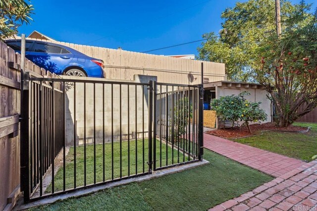 view of gate featuring a lawn