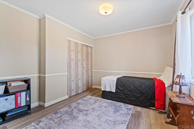 bedroom with hardwood / wood-style floors and ornamental molding