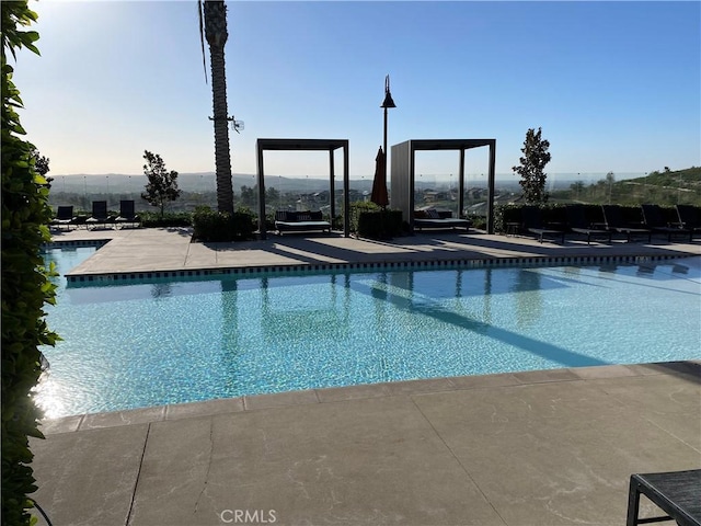 view of swimming pool with a mountain view and a patio