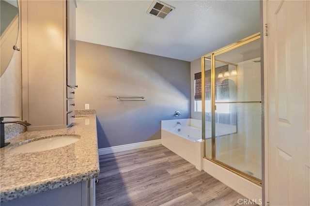 bathroom featuring vanity, hardwood / wood-style flooring, and shower with separate bathtub