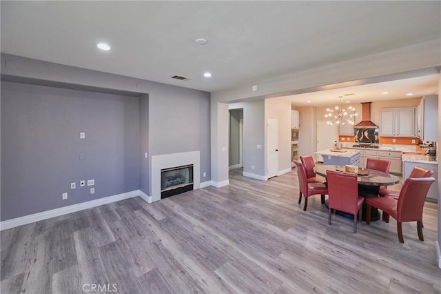 dining room with a notable chandelier and light hardwood / wood-style flooring