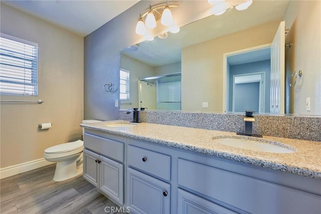 bathroom featuring vanity, toilet, a shower with shower door, and hardwood / wood-style floors