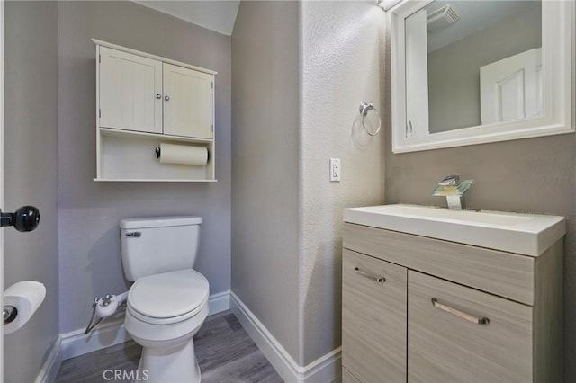 bathroom with vanity, wood-type flooring, and toilet