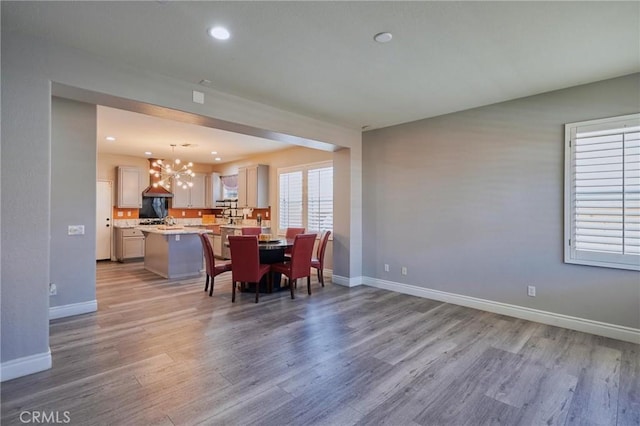 dining space featuring a notable chandelier and light wood-type flooring