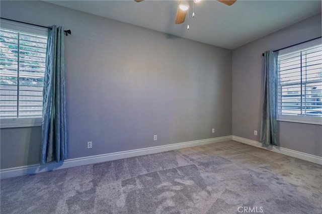 carpeted spare room featuring ceiling fan and a healthy amount of sunlight