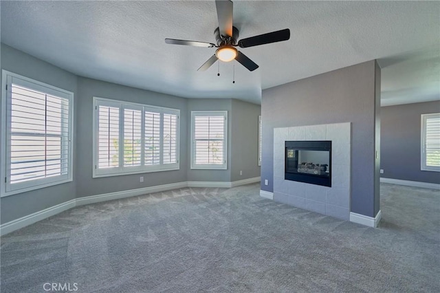 unfurnished living room featuring plenty of natural light, a fireplace, and carpet