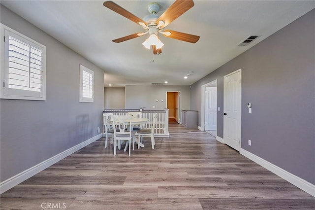 unfurnished dining area with wood-type flooring and ceiling fan