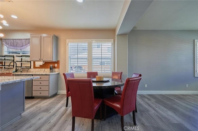 dining room featuring sink and light hardwood / wood-style flooring