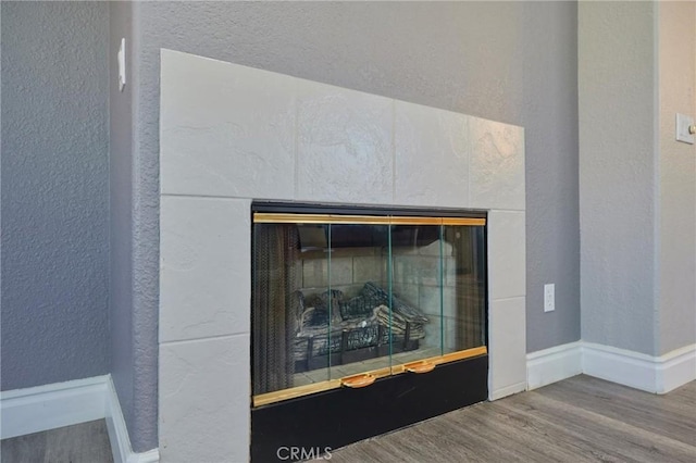 interior details featuring a fireplace and wood-type flooring