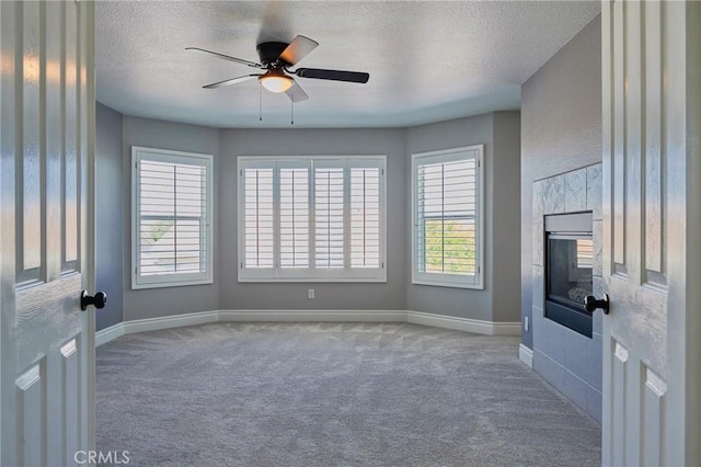 unfurnished living room with ceiling fan, a textured ceiling, and carpet flooring