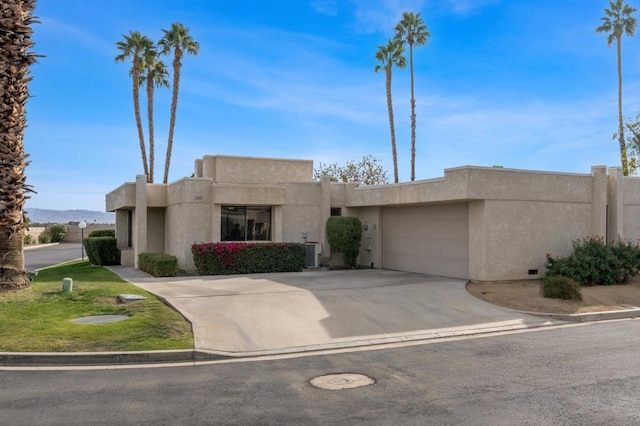 southwest-style home featuring a garage and central air condition unit