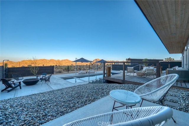 exterior space with an outdoor fire pit, a patio area, and a deck with mountain view