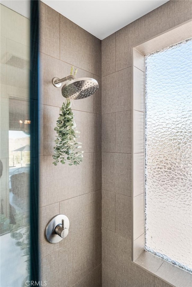 interior details featuring tiled shower