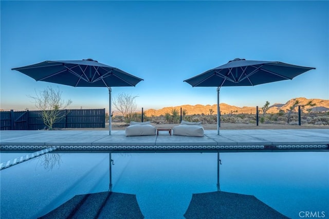 view of swimming pool with a mountain view and a patio