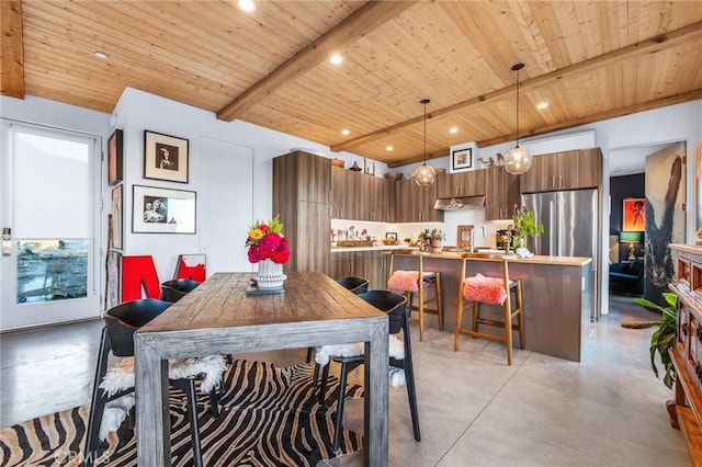 dining space with sink, beam ceiling, and wooden ceiling