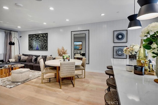 dining area featuring wooden walls and light hardwood / wood-style floors