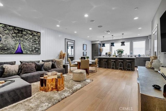 living room featuring light hardwood / wood-style floors and wood walls