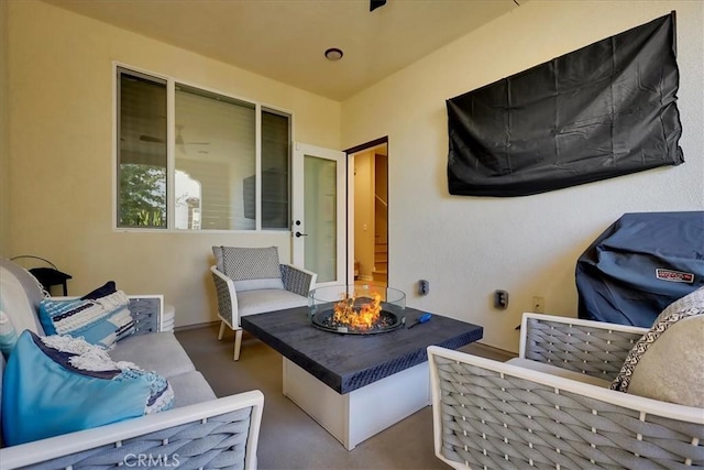 view of patio with an outdoor living space with a fire pit