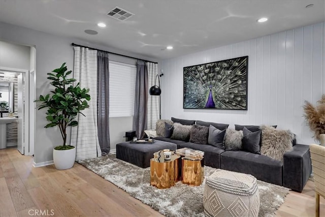 living room with wood walls and light hardwood / wood-style flooring