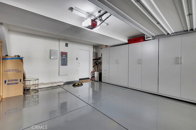 garage with a garage door opener and electric panel