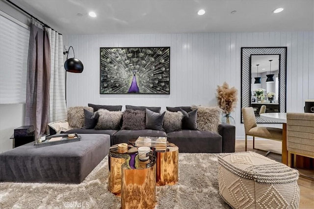 living room with hardwood / wood-style flooring and wood walls