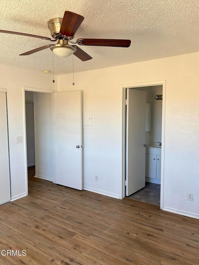 unfurnished bedroom featuring ceiling fan, a textured ceiling, and dark hardwood / wood-style flooring